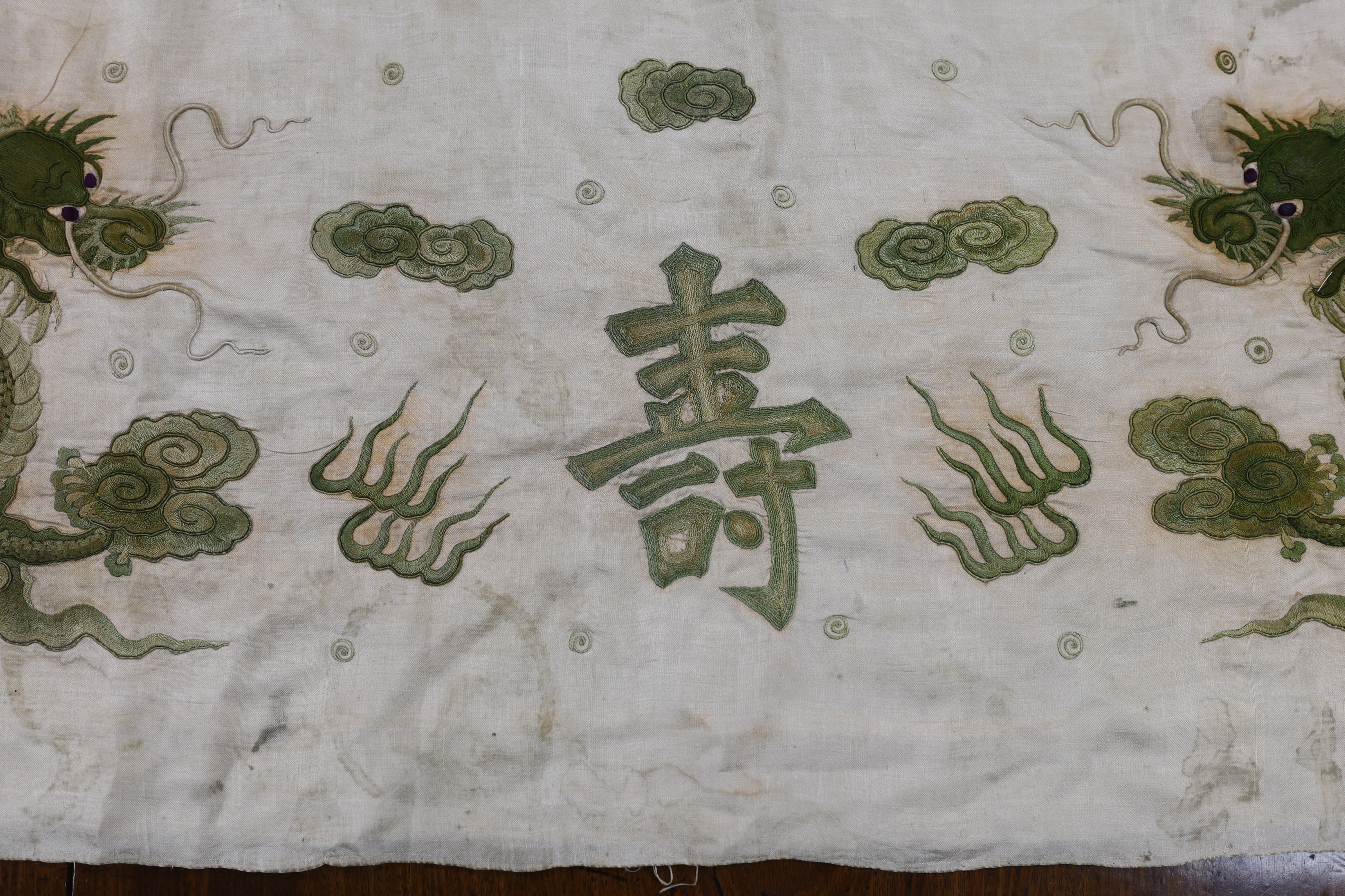 A collection of Chinese embroideries, to include a pair of tasselled embroidered panels to a wedding skirt, two pairs of Chinese children's shoes, a pair of embroidered sleeve bands, a panel of gauze of polychrome silk a
